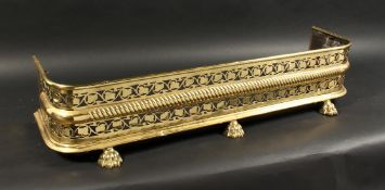 A 19TH CENTURY BRASS FENDER with pierced fretwork front on brass claw feet. 3ft 7ins long, 10ins