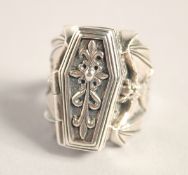 A SILVER AND BAT COFFIN RING.