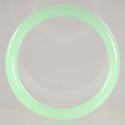 AN ICY JADE CELADON BANGLE. 3ins diameter.