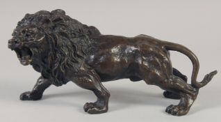 A BRONZE STANDING LION. 11ins long.