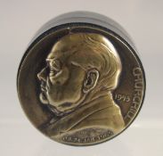 A SMALL CIRCULAR WOODEN BOX with cast gilt metal top, CHURCHILL, 1975 O.B. 24 JAN 1965. 2ins