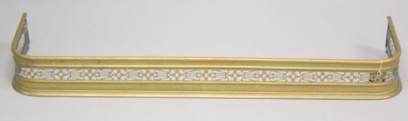 A 19TH CENTURY BRASS PIERCED FENDER on two bun feet. 3ft 9ins long, 1ft deep.