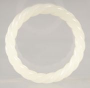 A WHITE JADE TWIST BANGLE. 3ins diameter.