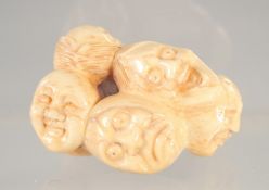 A CARVED BONE FACES NETSUKE.