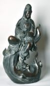 A LARGE CHINESE BRONZE FIGURE OF GUANVIN sitting atop a wave, holding a sceptre, bearing a six-