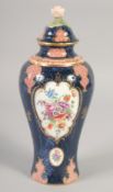 A ROYAL WORCESTER VASE AND COVER painted with flowers on a blue scale ground with red cell panels by