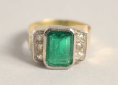 AN 18CT GOLD EMERALD AND DIAMOND RING, central Columbian emerald, 4ct, with three diamonds on each