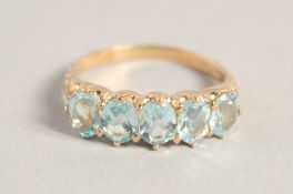 A 9CT GOLD FIVE STONE AQUAMARINE RING.