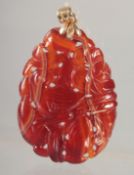 A CARVED JADE PENDANT with gold ring.