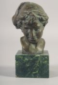 A SMALL BRONZE BUST OF A BOY on a marble base. 3.25ins high.