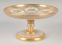 A 19TH CENTURY WHITE GLASS COMPORT painted with flowers and gilded.