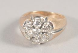 A GOLD AND DIAMOND SEVEN STONE CLUSTER RING.