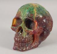 A CARVED AMBER STYLE SKULL.