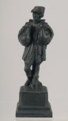 A SMALL CAST BRONZE FIGURE OF A MAN STANDING ON A PLINTH, with a goose in each arm. 15cm high.