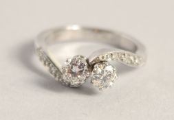 A PLATINUM TWO STONE DIAMOND CROSSOVER RING.