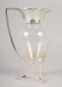 A CHRISTOPHER DRESSER STYLE SILVER PLATED AND GLASS CLARET JUG with crows’ feet.