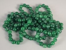 A LONG JADE STRING OF BEADS 50ins long.