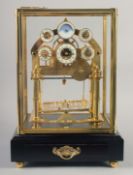 A VERY GOOD GILT MOONPHASE CONGREAVE CLOCK with six dials in a glass frame, the base with single