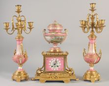 A SUPERB LOUIS XVI GILT BRONZE AND PINK PORCELAIN CLOCK GARNITURE DE CHEMINEE. The clock with Madame