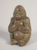 A SMALL JAPANESE BRONZE SEATED GORILLA. 1.75ins high.