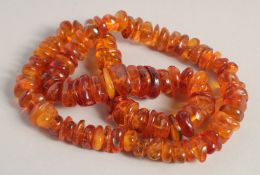 AN AMBER NECKLACE. 26ins long.