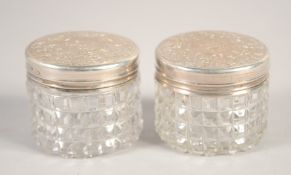 A SMALL PAIR OF VICTORIAN SILVER TOP CIRCULAR BOTTLES. 1.5ins diameter.