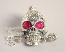 A SILVER SKULL holding a rose, on a chain.