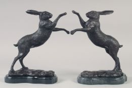 A GOOD PAIR OF BRONZE BOXING HARES on marble bases. 12ins high.