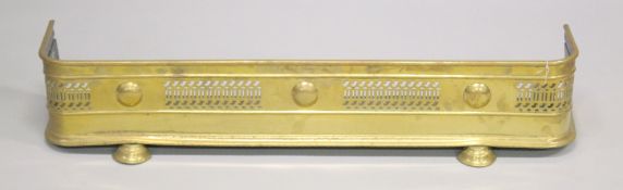A 19TH CENTURY BRASS PIERCED FENDER on two bun feet. 3ft 5ins long, 8ins deep.