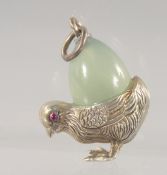 A SILVER AND JADE PENDANT, modelled as a chick carrying an egg on its back. 3cm high.