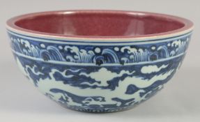 A CHINESE BLUE, WHITE AND COPPER RED BOWL decorated with dragons, six character mark to base. 27.5cm