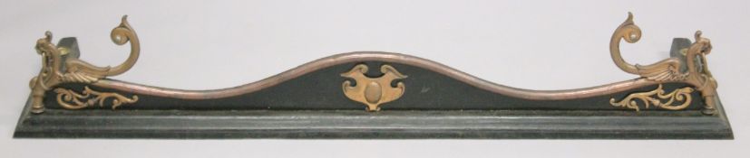 A VICTORIAN STEEL AND CAST IRON SERPENTINE SHAPED FENDER with lion ring handles. 4ft 4ins long,