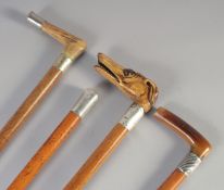 A 19TH CENTURY MALACCA WALKING STICK with GREYHOUND handle and three others. (4).