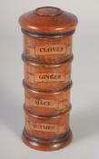 A WOODEN SPICE TOWER: CLOVES, GINGER, MACE NUTMEG.