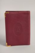 A CARTIER LEATHER WALLET in a red Cartier velvet case.