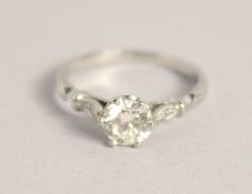 A SOLITAIRE DIAMOND RING with diamond shoulders.