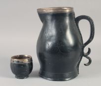 A BLACK LEATHER JUG with silver mounts and scroll handle, 14.5ins high, plus an associated silver
