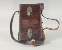 A LEATHER CARTRIDGE CASE 17cm x 11cm, with cross guns in relief and leather strap.