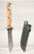 A PUMA KNIFE, with antler handle, in a leather sheath. 7.5