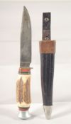 A PUMA KNIFE, with antler handle, in a leather sheath, 7.5