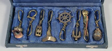 A COLLECTION OF BRASS KEY RINGS, of diving helmet, ships wheel, lantern, anchor etc.