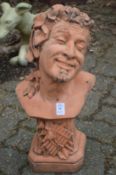 A terracotta colour garden ornament modelled as the bust of a fawn.