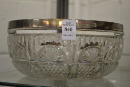 A cut glass bowl with silver rim.