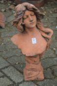 A terracotta coloured classical bust of a young woman.