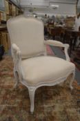 A large French style upholstered open armchair with painted frame.