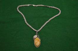 A silver pendant and chain.