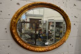 Decorative gilt framed oval wall mirror.