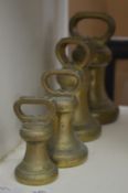 A graduated set of four brass bell weights.