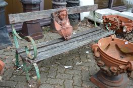 A wrought iron and wooden slatted garden bench.
