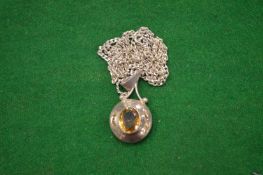 A silver pendant and chain.